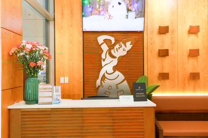 The entrance to SH Premium Lounge at Chu Lai International Airport features a reception desk with informational signage and floral decoration.