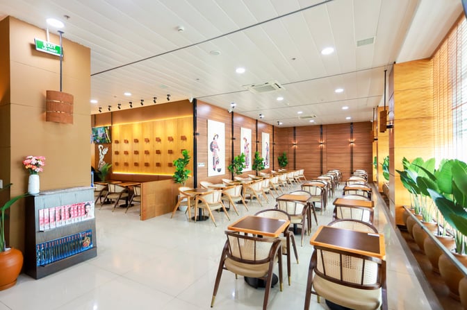 The SH Premium Lounge at Chu Lai International Airport features a spacious seating area with tables and chairs, complemented by decorative plants.