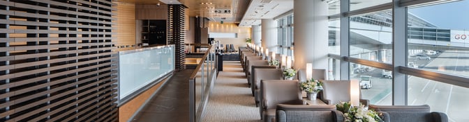 The Plaza Premium Lounge at Chubu Centrair International Airport features a seating area with tables, lamps, and views of the tarmac.