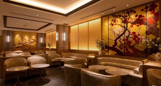 Seating area in The Coral Executive Lounge at Chubu Centrair International Airport features comfortable chairs and tables with decorative wall panels.