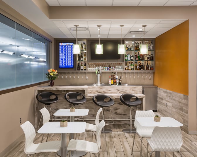 The Escape Lounge at Cincinnati/Northern Kentucky International Airport features a bar with complimentary beverages and seating for travelers.