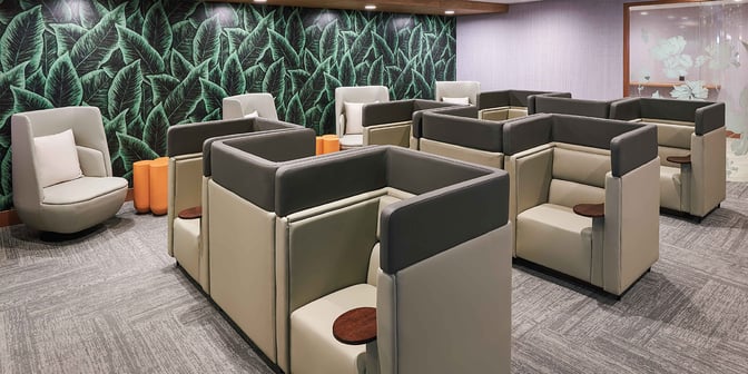 Semi-private seating pods in the Plaza Premium Lounge at Clark International Airport offer individual spaces with small tables for travelers.
