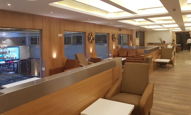 The BlackBerry Lounge at Coimbatore International Airport features comfortable seating areas with tables, offering a view of the terminal below.