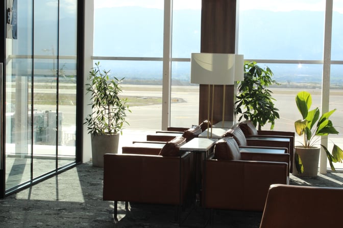 Seating area in the VIP Lounge at Comayagua International Airport offers armchairs and tables with views of the runway.