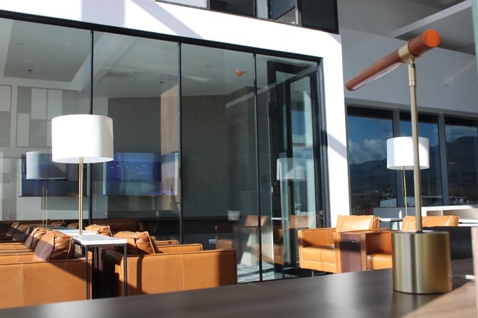 The VIP Lounge at Comayagua International Airport features comfortable seating with tables and lamps, adjacent to large glass windows.