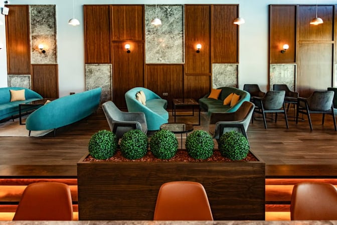 The seating area in the Condor Lounge at Comodoro Arturo Merino Benítez International Airport features sofas and chairs for passenger relaxation.