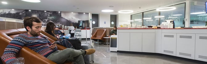 The lounge at Comodoro Arturo Merino Benítez International Airport features comfortable seating and a self-serve food area with beverages.