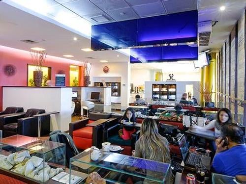 Comodoro Arturo Merino Benítez International Airport "The Lounge" in the Domestic Terminal features seating areas with tables and self-serve food stations for travelers.