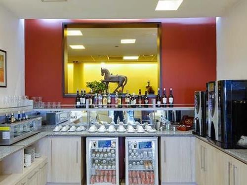 The bar area at Comodoro Arturo Merino Benítez International Airport "The Lounge" in the Domestic Terminal offers a selection of wines, spirits, and self-serve beverages.