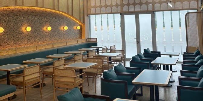 The seating area in SH Premium Lounge at Con Dao Airport features tables with cushioned chairs and booth seating for travelers.