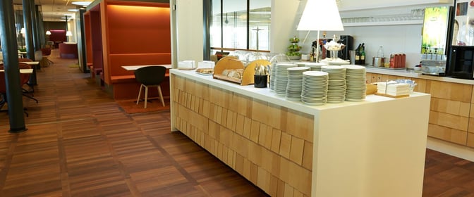 The Aspire Lounge at Copenhagen Airport features a self-serve food area with plates, cutlery, and a selection of snacks and beverages.
