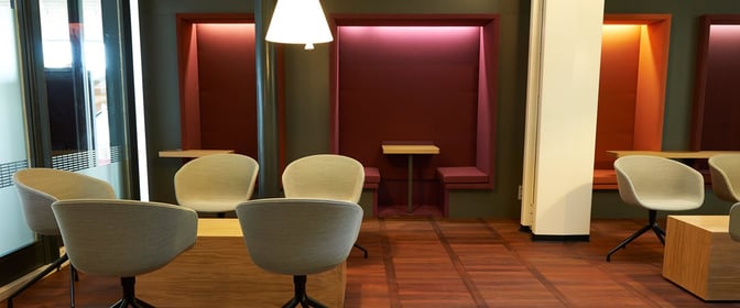 The Aspire Lounge at Copenhagen Airport features booth seating with small tables and chairs for comfortable waiting and relaxation.