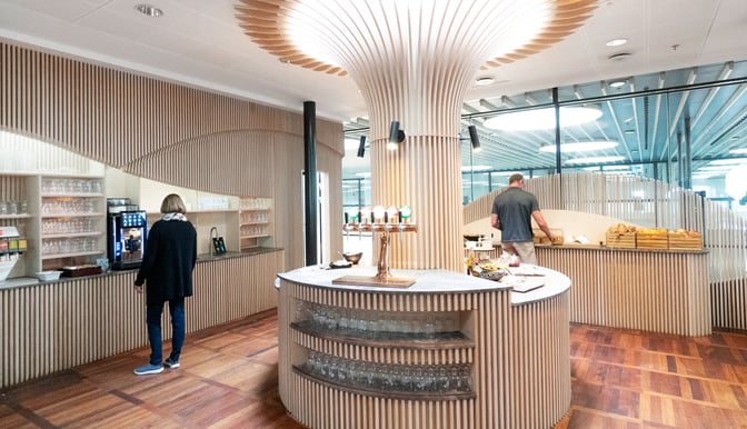 The Carlsberg Aviator Lounge at Copenhagen Airport features a self-serve beverage station with taps and a counter for snacks.