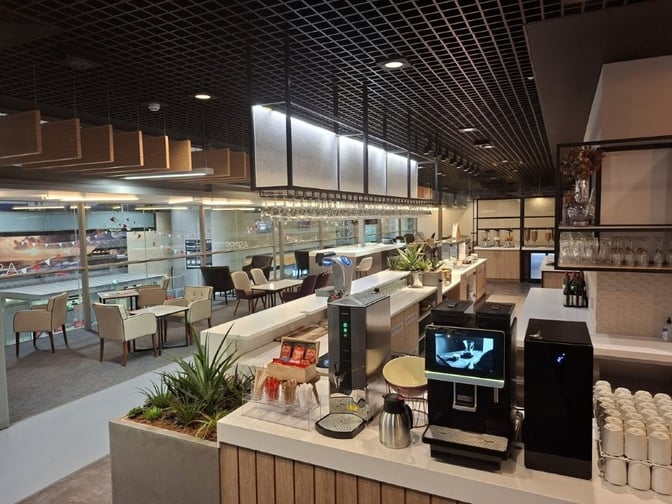 The Kinsale Lounge at Cork Airport features a self-serve beverage station with coffee machines and seating overlooking the terminal area.