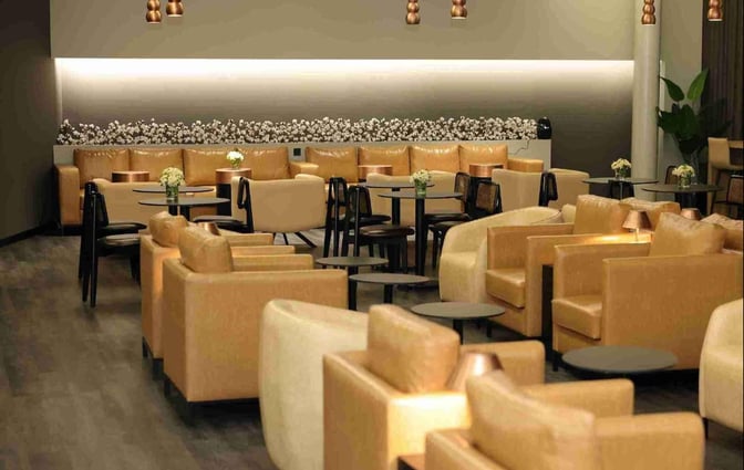 Seating area in the Celebi COV International Lounge features armchairs and tables, providing a comfortable space for travelers at Cukurova International Airport.