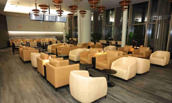 The Celebi COV International Lounge at Cukurova International Airport features a spacious seating area with armchairs and small tables.