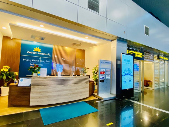The entrance to the Vietnam Airlines Domestic Lounge at Da Nang International Airport features a reception desk and informational signage.