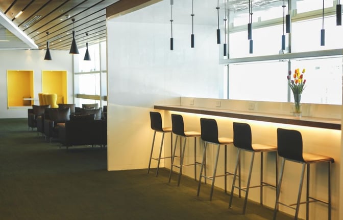 The CIP Orchid Lounge at Da Nang International Airport features a counter seating area with bar stools and a seating area with armchairs.