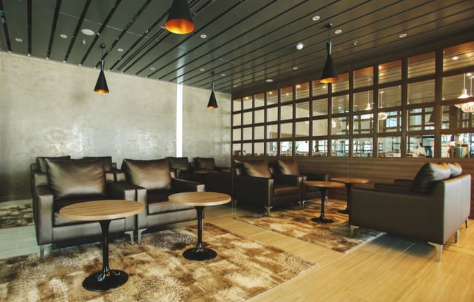 The seating area in the CIP Orchid Lounge at Da Nang International Airport features comfortable armchairs and small tables for travelers.