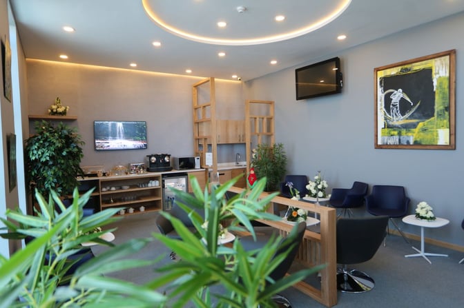 The Pearl Lounge at Dakhla Airport features a seating area with tables, chairs, and a self-serve beverage station.