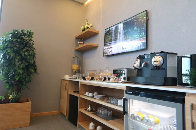 The Pearl Lounge at Dakhla Airport features a self-serve beverage station with a coffee machine, glassware, and a mini-fridge.