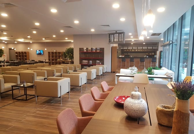 The DLM Lounge at Dalaman Airport features a seating area with armchairs, a bar with high stools, and a communal table.