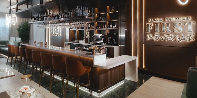 The Plaza Premium First lounge at Dallas-Fort Worth Airport features a bar with counter seating and a selection of spirits and wines.