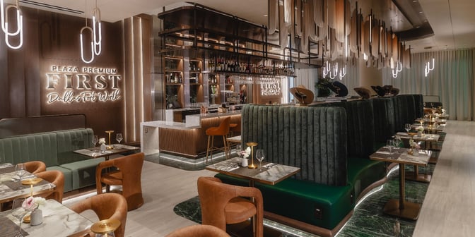 The Plaza Premium First lounge at Dallas-Fort Worth International Airport features a bar with seating and dining tables for guests.
