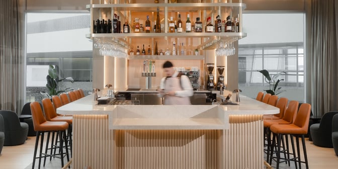 The bar at Plaza Premium Lounge in Dallas-Fort Worth Airport offers a selection of spirits with counter seating available.