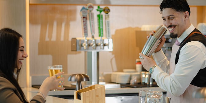 The bar at Plaza Premium Lounge in Dallas-Fort Worth International Airport features draft beer taps and a bartender preparing a cocktail.