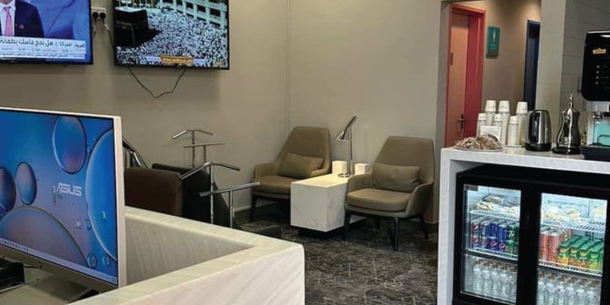 The Hayyak Lounge at Dawadmi Domestic Airport features a seating area with armchairs, a beverage station, and a display of refreshments.