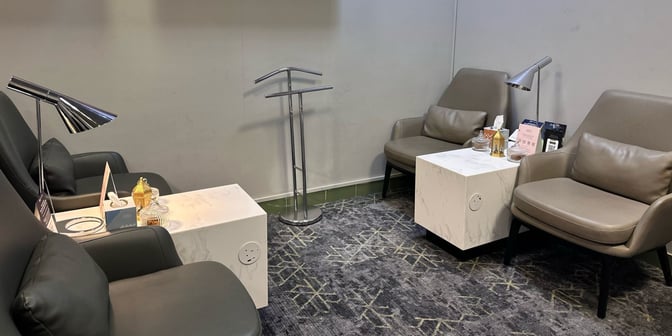 The seating area in Hayyak Lounge at Dawadmi Domestic Airport features comfortable chairs, side tables with power outlets, and reading lamps.