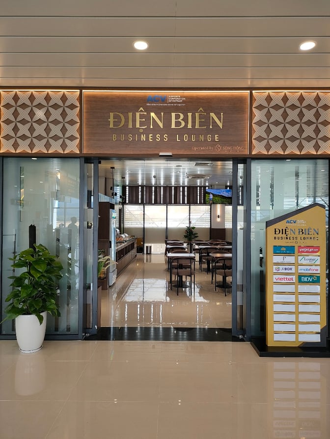 The entrance to the Điện Biên Business Lounge at Điện Biên Phủ Airport features glass doors and a seating area visible inside.
