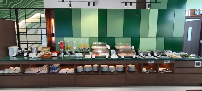 The SH Premium Lounge at Dien Bien Phu Airport features a self-serve buffet with various food options and beverage dispensers.