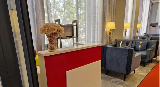 The Beira Lounge at Djibouti–Ambouli International Airport features a reception desk with floral decor and comfortable seating with lamps.