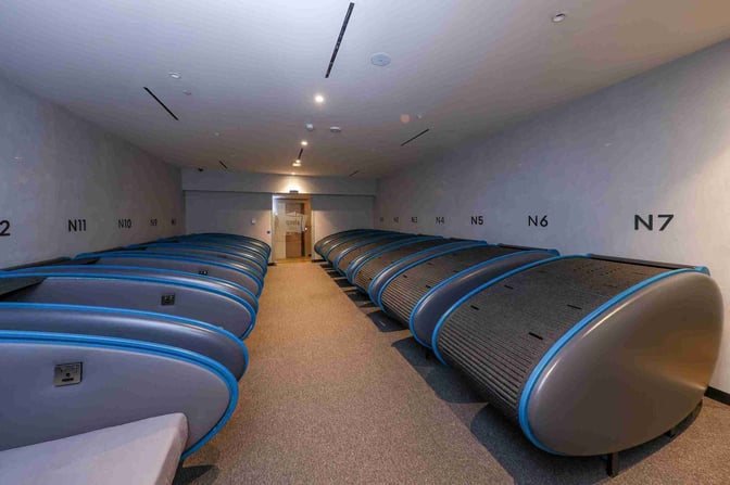 The Sleepover North Node at Doha Hamad International Airport features individual sleep pods with numbered designations for passenger rest.