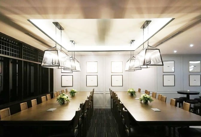 The Coral Finest Business Class Lounge at Don Mueang International Airport features a long communal table with seating for group dining.