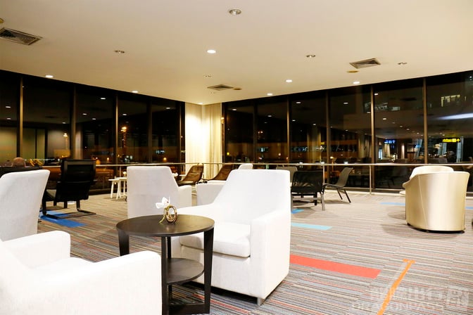 The seating area in Miracle Lounge No. 1 at Don Mueang International Airport features comfortable chairs and tables with airport views.