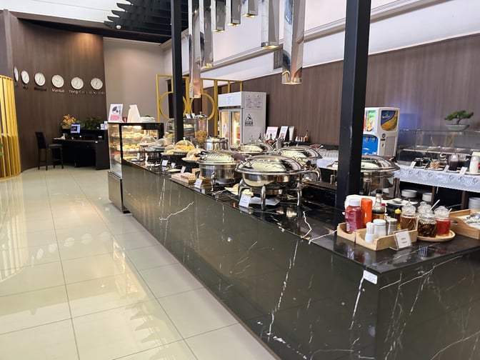 The Miracle Lounge No. 2 at Don Mueang International Airport features a buffet area with self-serve hot dishes and condiments.