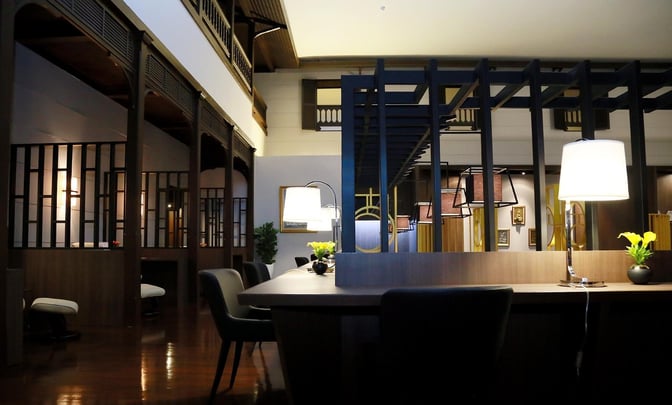 The Miracle Lounge No. 2 at Don Mueang International Airport features semi-private seating areas with tables and lamps for travelers.