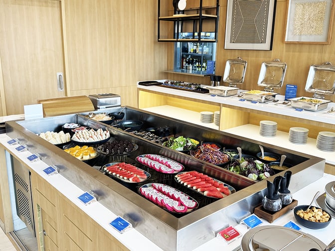The Travel Club lounge at Don Mueang International Airport features a self-serve buffet with a variety of fresh fruits and salads.