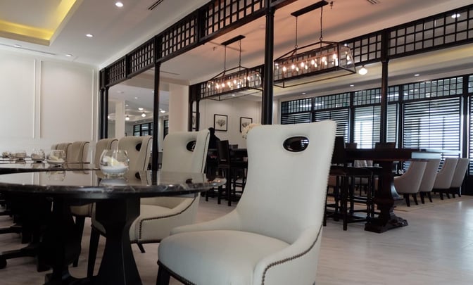 The Coral Executive Lounge at Don Mueang International Airport features comfortable seating and tables for dining and relaxation.