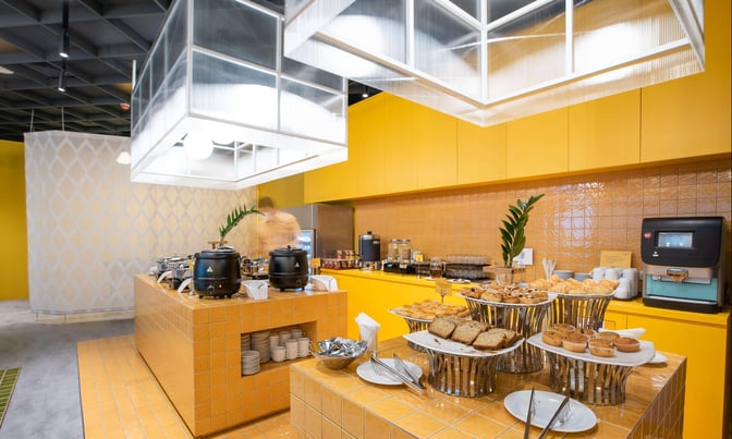 Self-serve food area in the Nok Air Lounge at Don Mueang Airport offers a variety of pastries and hot beverages.