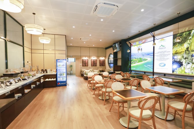 The SH Premium Lounge at Dong Hoi Airport features a self-serve food area with a beverage fridge and ample seating.