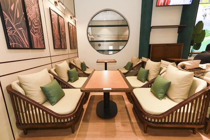 Seating area in SH Premium Lounge Dong Hoi features cushioned chairs and tables, providing a comfortable space for travelers to relax.