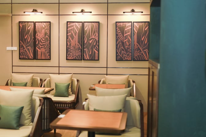 The seating area in SH Premium Lounge Dong Hoi features cushioned chairs and tables, with decorative wall art enhancing the ambiance.