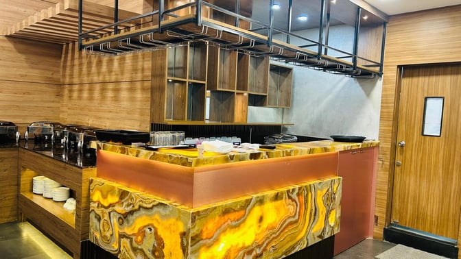 The Airr Lounge at Dr. Babasaheb Ambedkar International Airport features a buffet area with chafing dishes and a counter for dining essentials.
