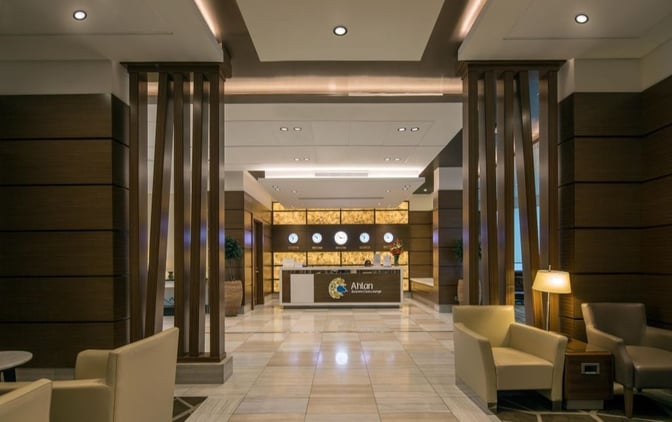 The Ahlan Business Class Lounge entrance at Dubai International Airport Concourse D features a reception desk and comfortable seating for guests.