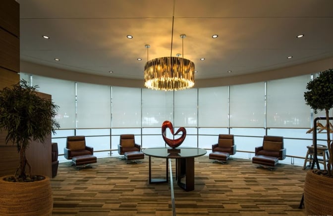 The Ahlan Business Class Lounge at Dubai International Airport Concourse D features a seating area with armchairs and a central decorative table.