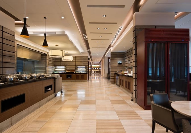 The Ahlan Business Class Lounge at Dubai International Airport Concourse D features a buffet area with self-serve hot dishes and seating.